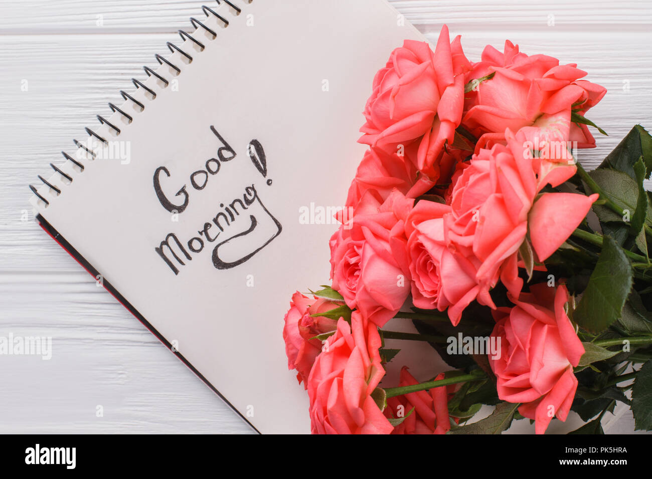 Rose flowers and good morning wish in notepad. Close up. White ...