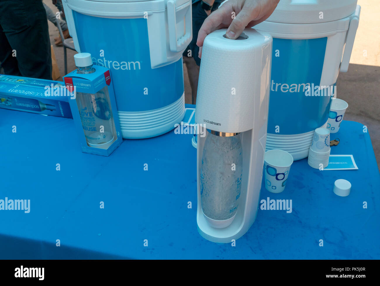 A Soda Stream worker demonstrates the carbonation method at the 'Drowning Liberty' installation unveiling at a SodaStream branding event in Flatiron Plaza in New York on Monday, September 3, 2018. The installation in partnership with the Oceanic Society consists of a 20 foot tall Lady Liberty trapped inside a cage filled with single-use containers. The event promotes the use of reusable containers, something that SodaStream does.  (Â© Richard B. Levine) Stock Photo