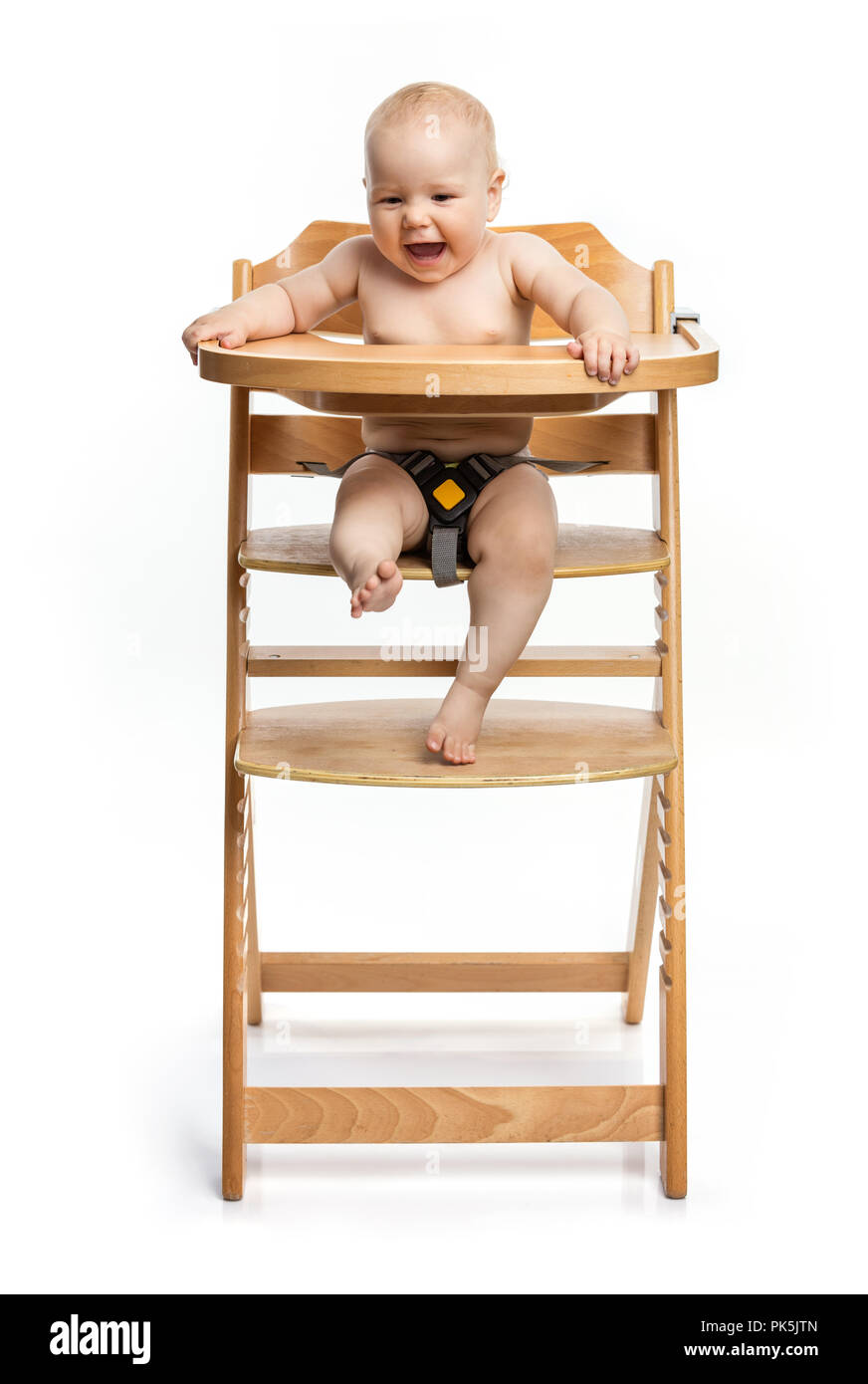 Happy cute baby girl sitting in high chair over white background Stock Photo