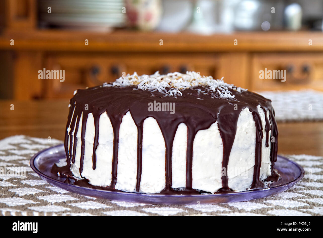 Delicious cake with chocolate drizzling down sides of white frosting
