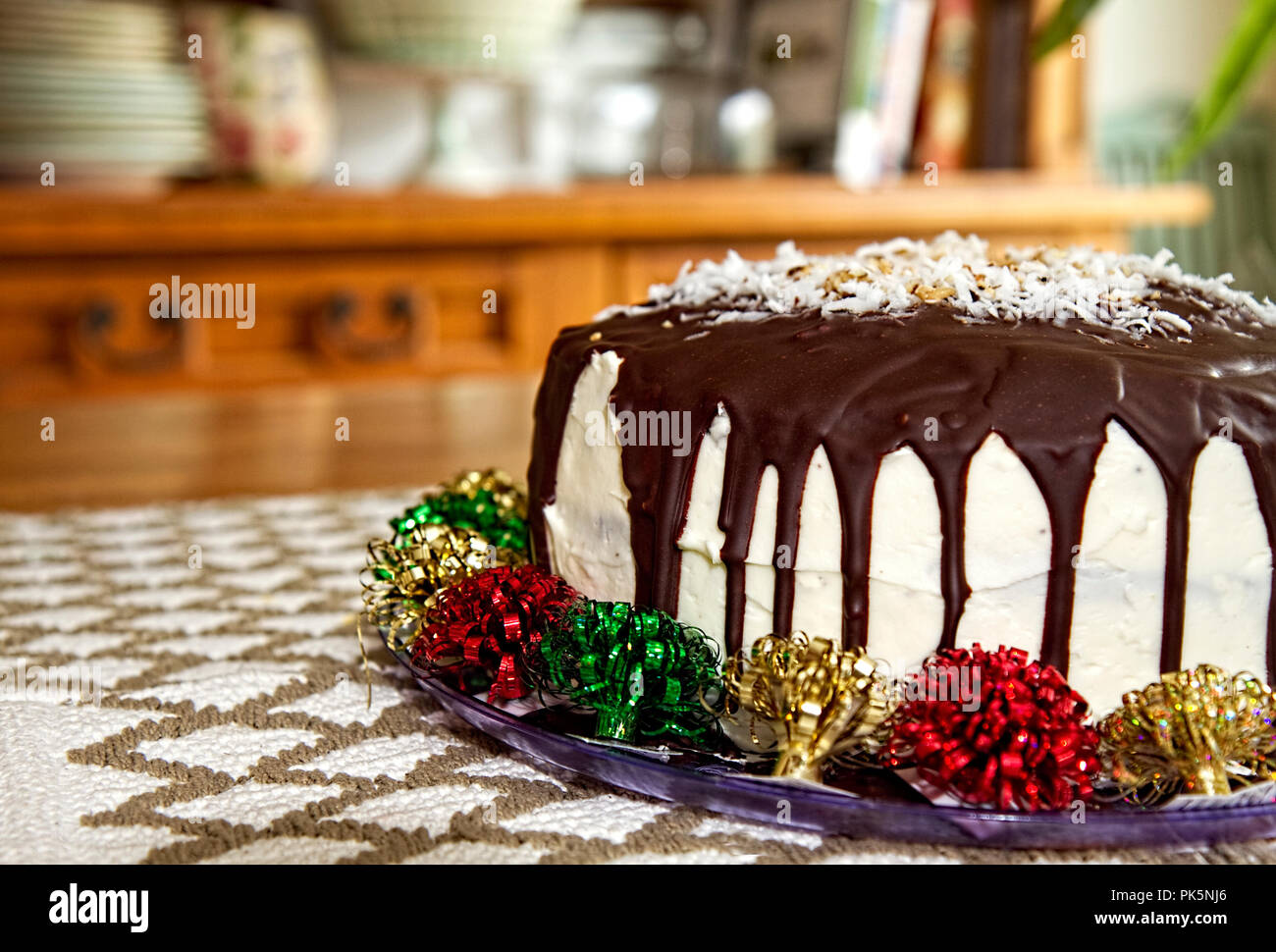Delicious cake with chocolate drizzling down sides of white frosting