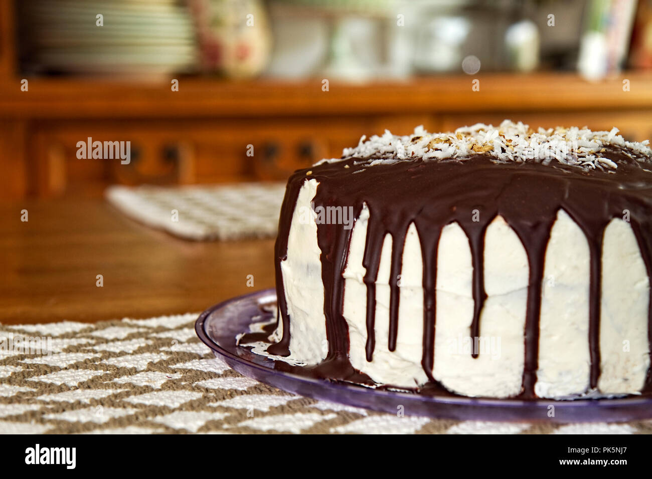 Delicious cake with chocolate drizzling down sides of white frosting