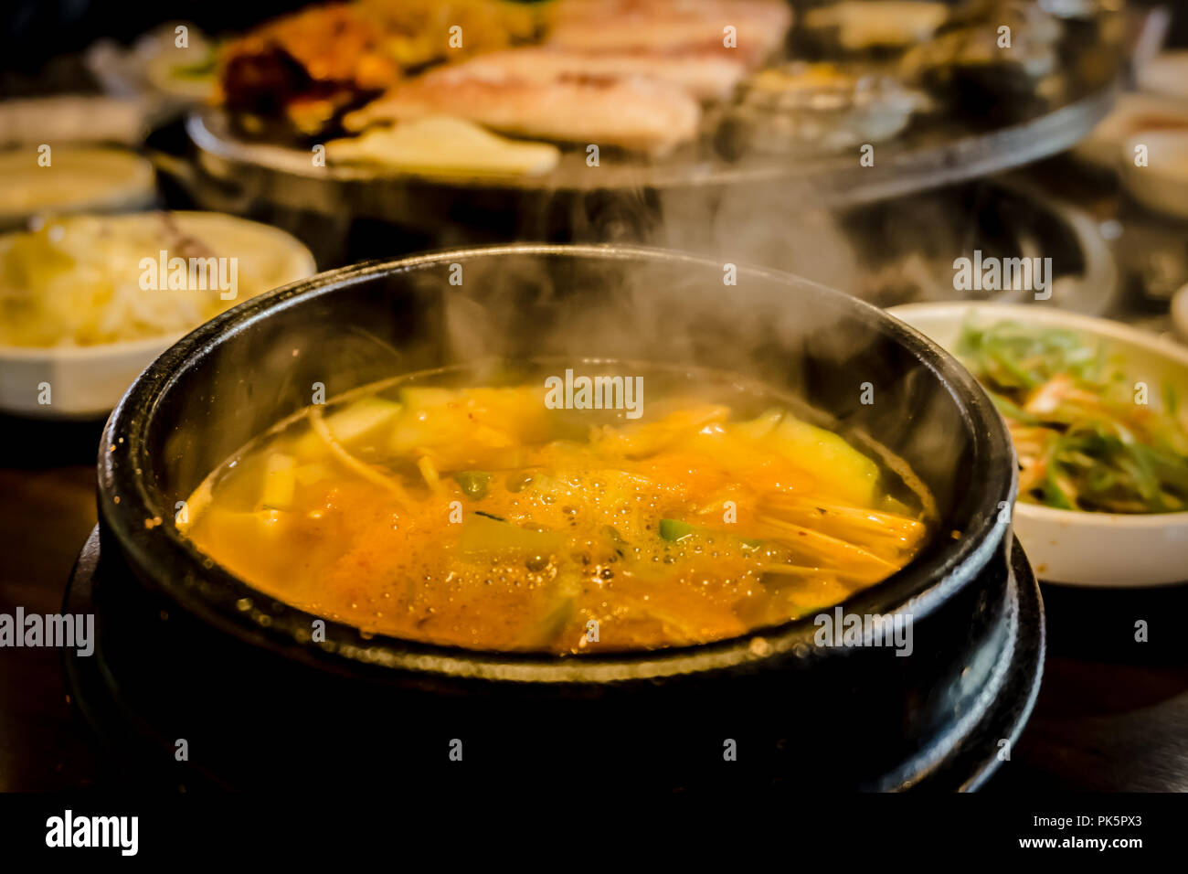 Eating BBQ Black Pork, abalones and side dishes and soup in Black Port Street restaurant in Jeju Island.  Close up view of the soup. Stock Photo