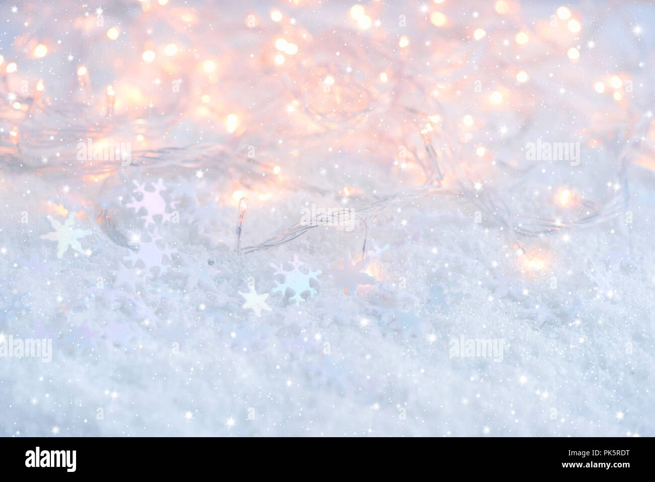 Christmas lights with snowflakes on snow. Christmas festive background Stock Photo