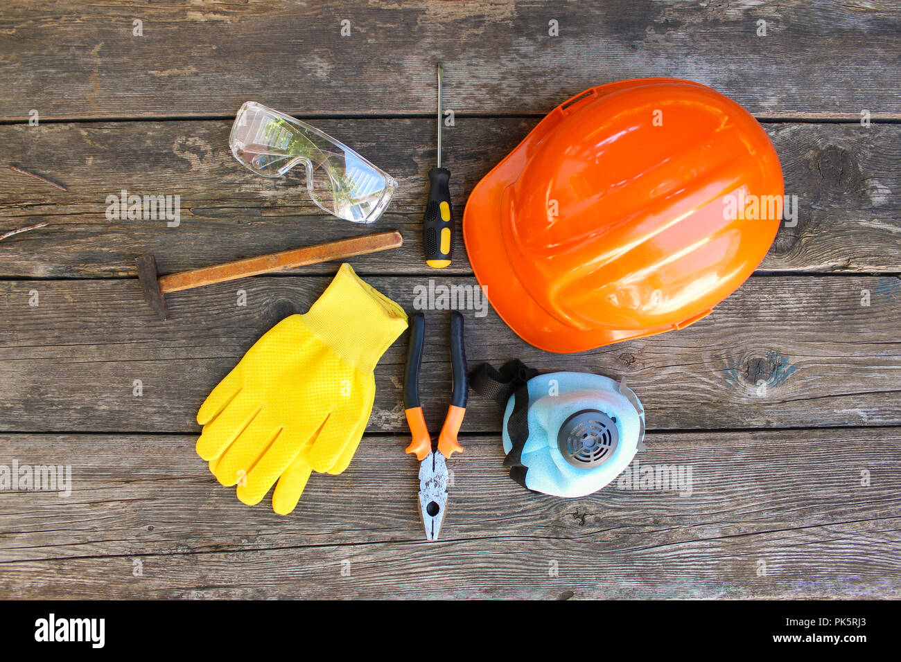 Construction tools and means of protection on an old wooden background. Top view, flat lay. Stock Photo