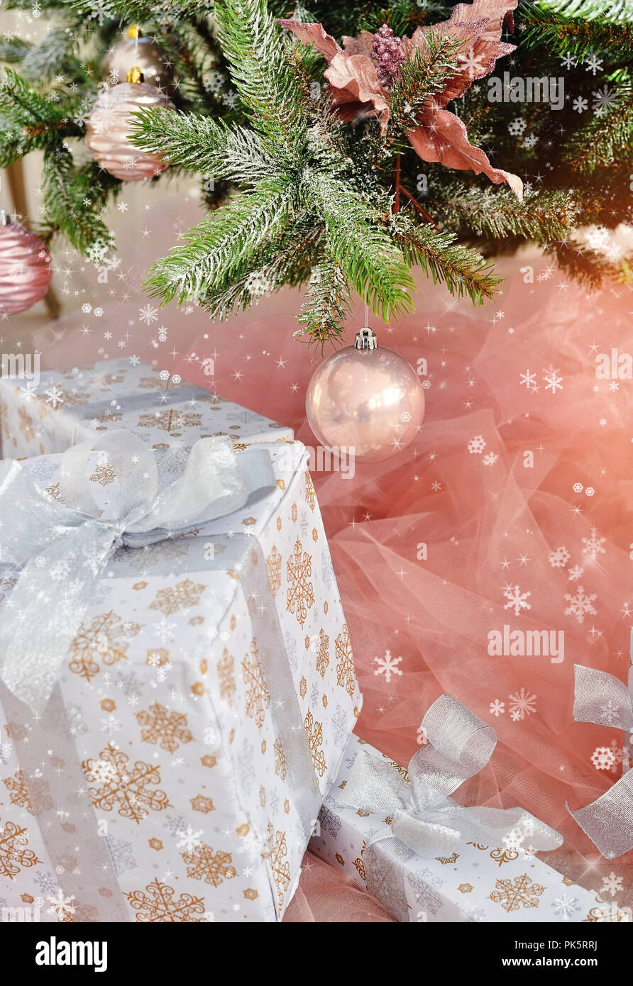 Pink decorative ball on the christmas tree with christmas presents. Merry christmas card. Winter xmas theme. Happy New Year. Stock Photo