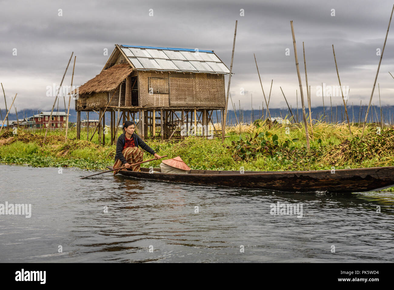 Local woman of the Inthar tribe boating through her village Stock Photo