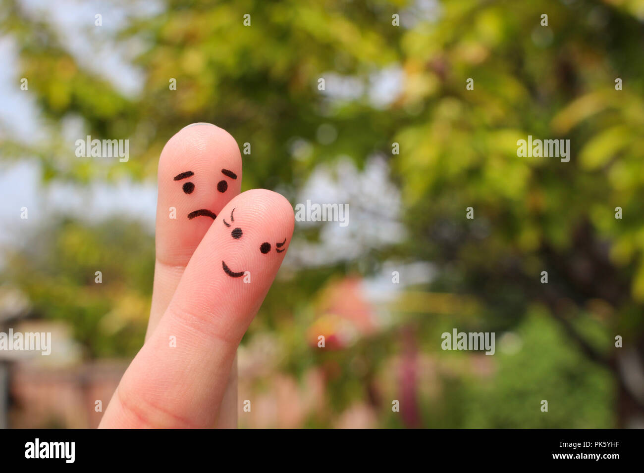 Finger art of couple. Woman is cheerful, man is sad. Stock Photo