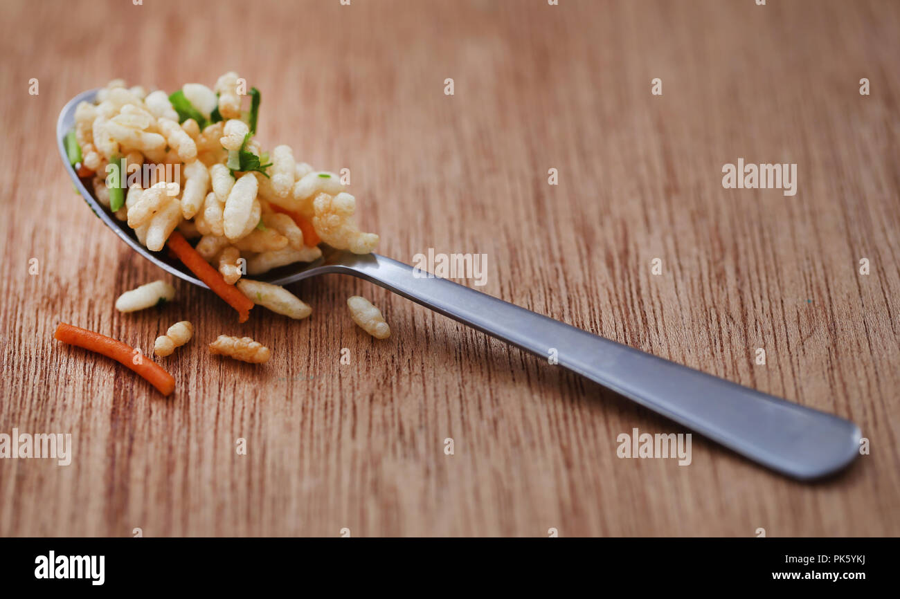 Puffed with hot spices and Bombay mix in a spoon Stock Photo