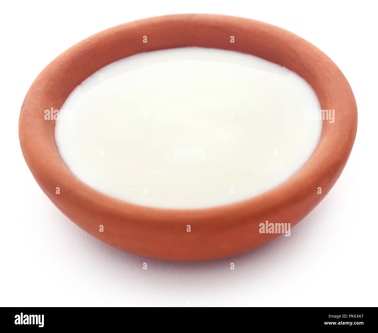 Fresh milk in a clay pottery over white background Stock Photo