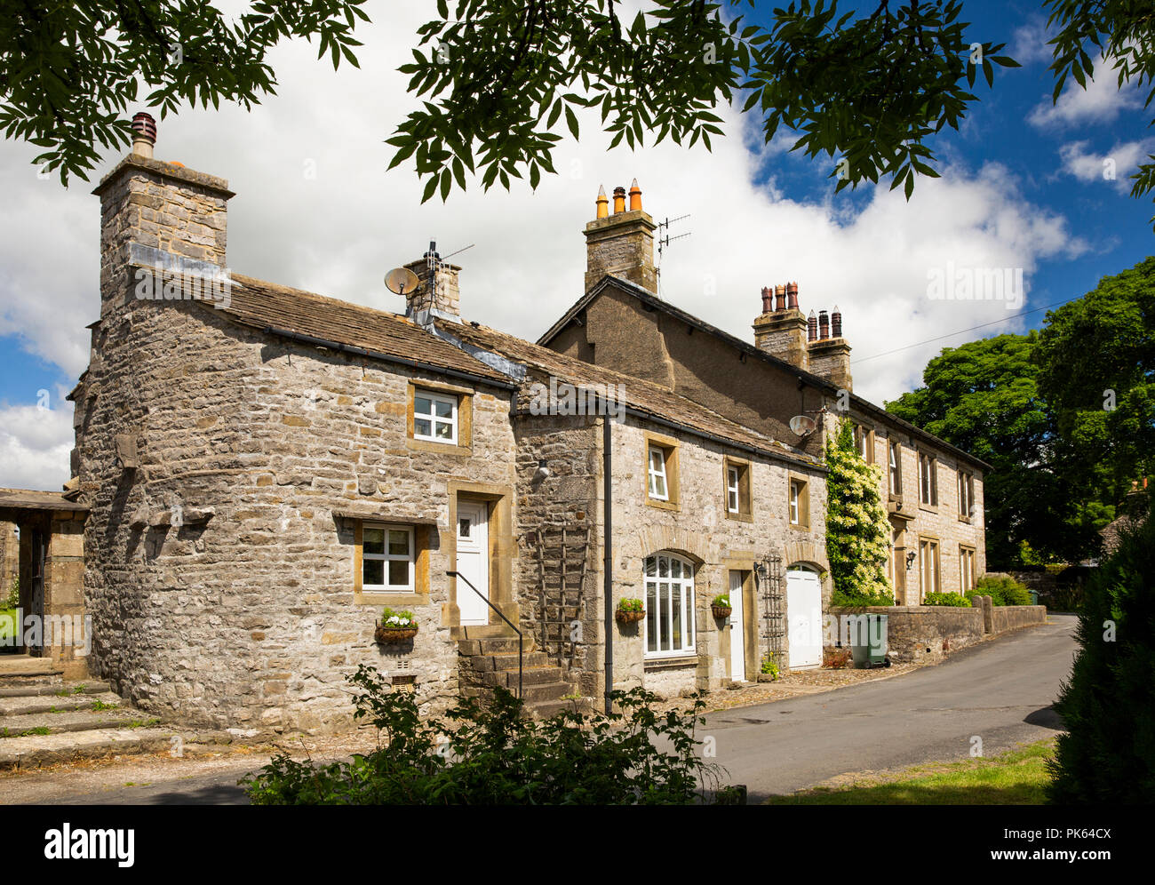 UK, Yorkshire, Horton in Ribblesdale, house with curved wall beside church lychgate Stock Photo