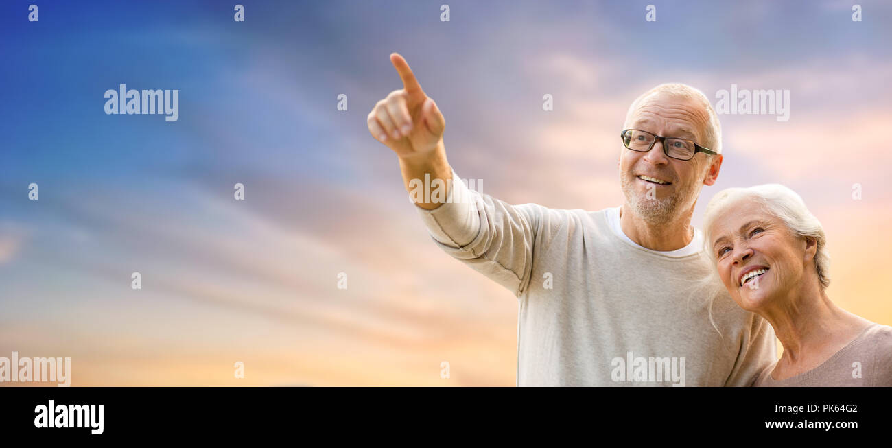 happy senior couple holding hands over evening sky Stock Photo