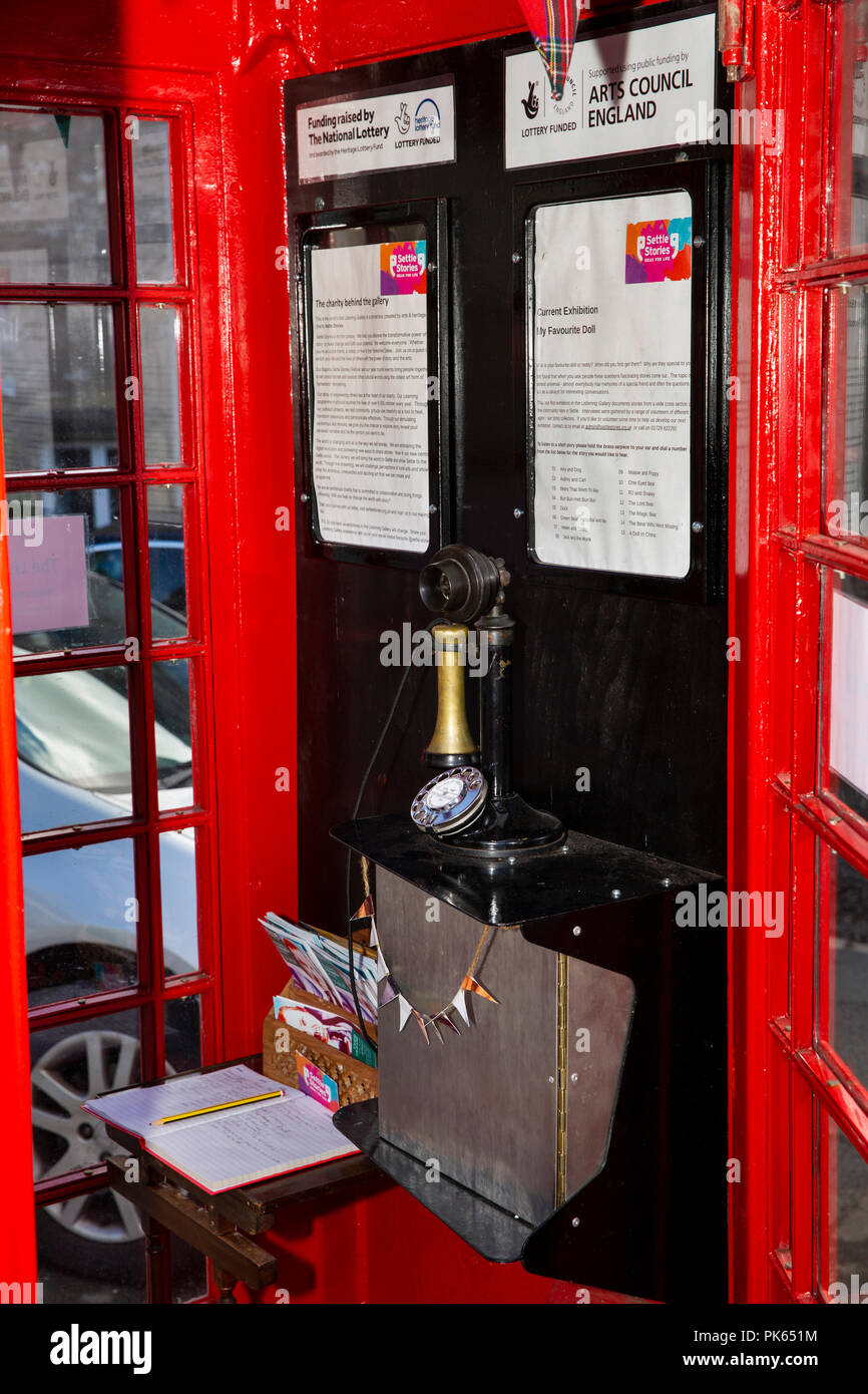 UK, Yorkshire, Settle, Duke St, Gallery with audio on old candlestick telephone, in old red K6 phone box Stock Photo