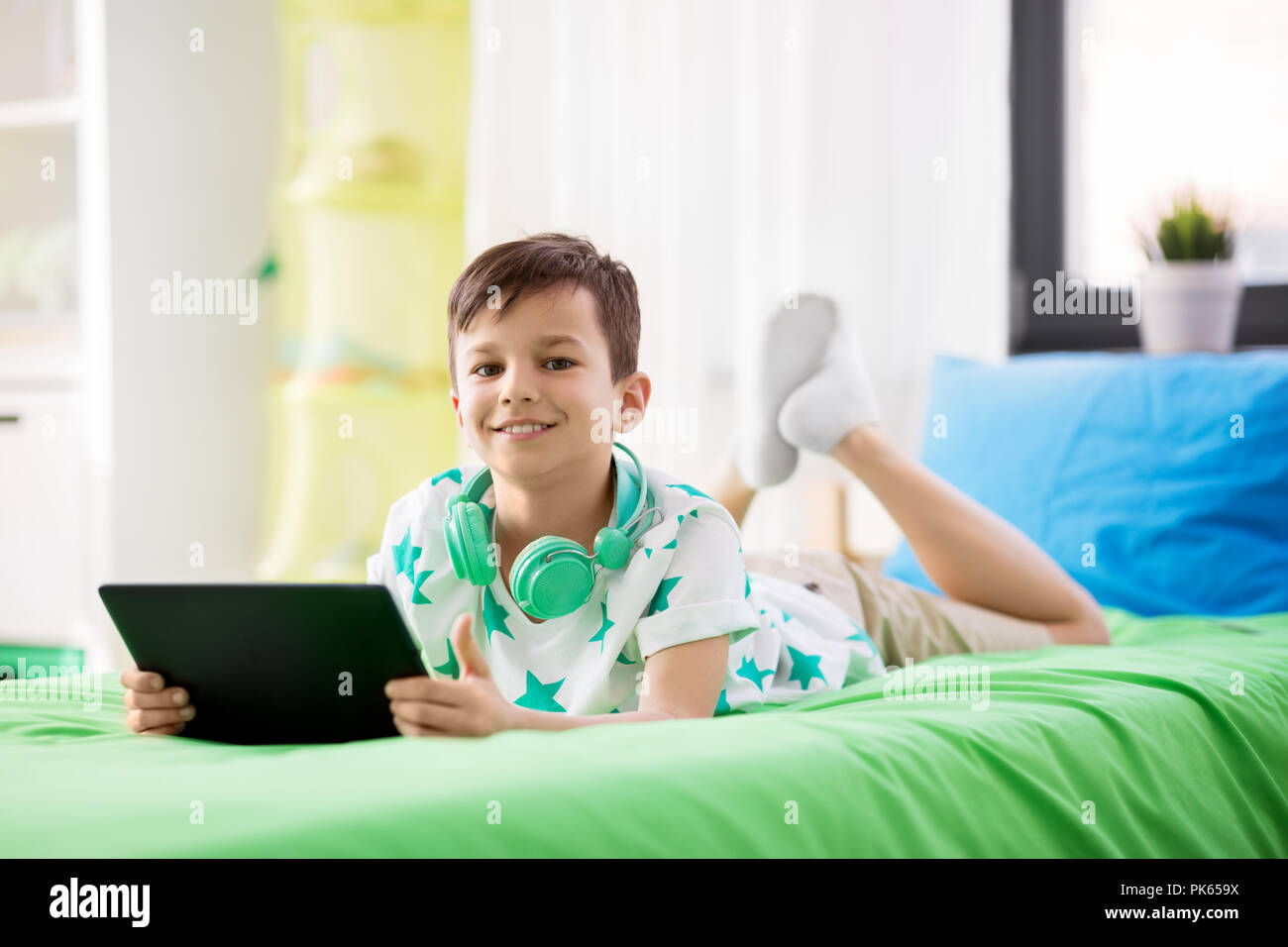 smiling boy with tablet pc computer at home Stock Photo - Alamy