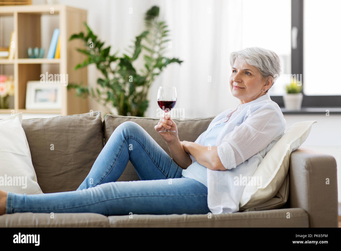 senior woman with glass of red wine at home Stock Photo