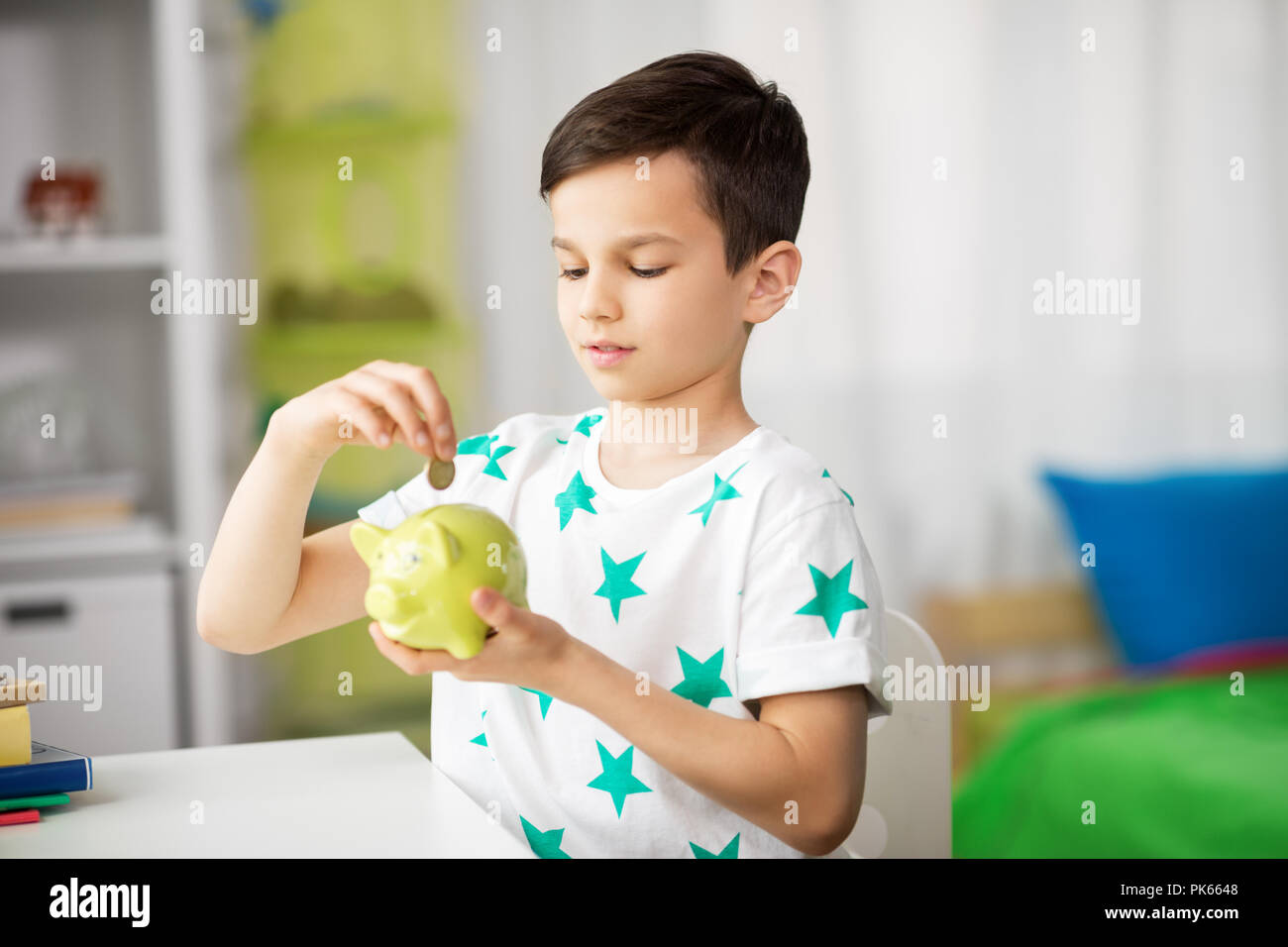 little boy putting coin into piggy bank at home Stock Photo - Alamy