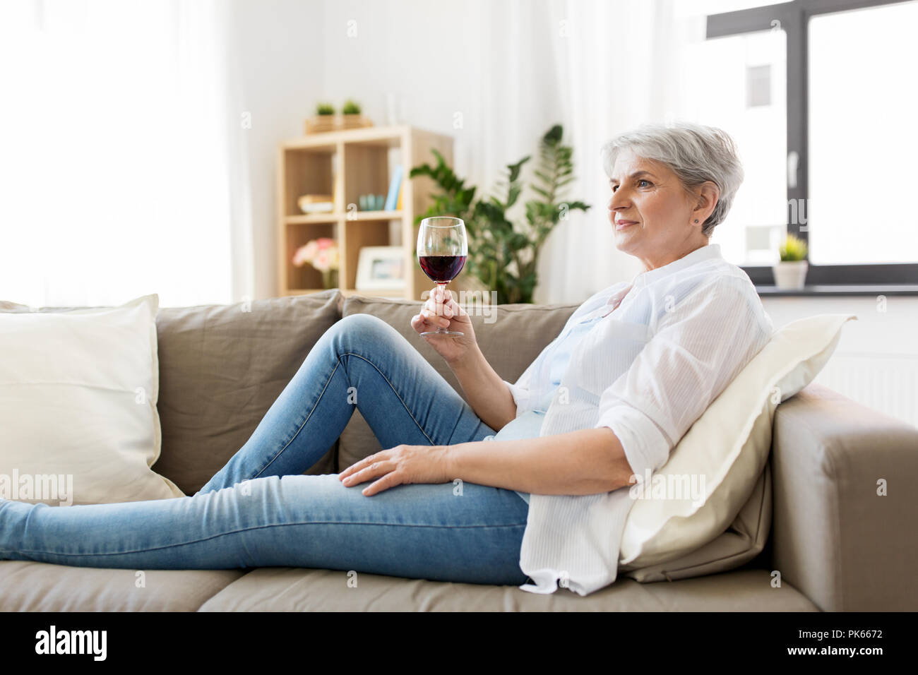 senior woman with glass of red wine at home Stock Photo