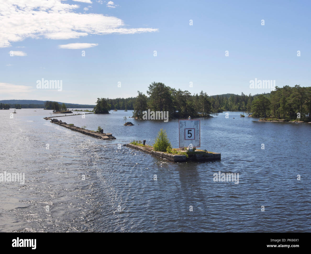 Stone wall built to guide the ships crossing the Viken lake on the Göta canal, boat cruise along an idyllic waterway in Sweden Stock Photo