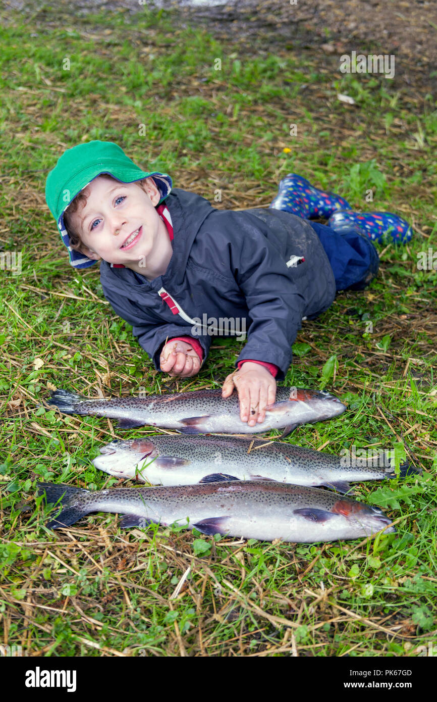 Four year old boy with his three large rainbow trout fish, Meon Springs