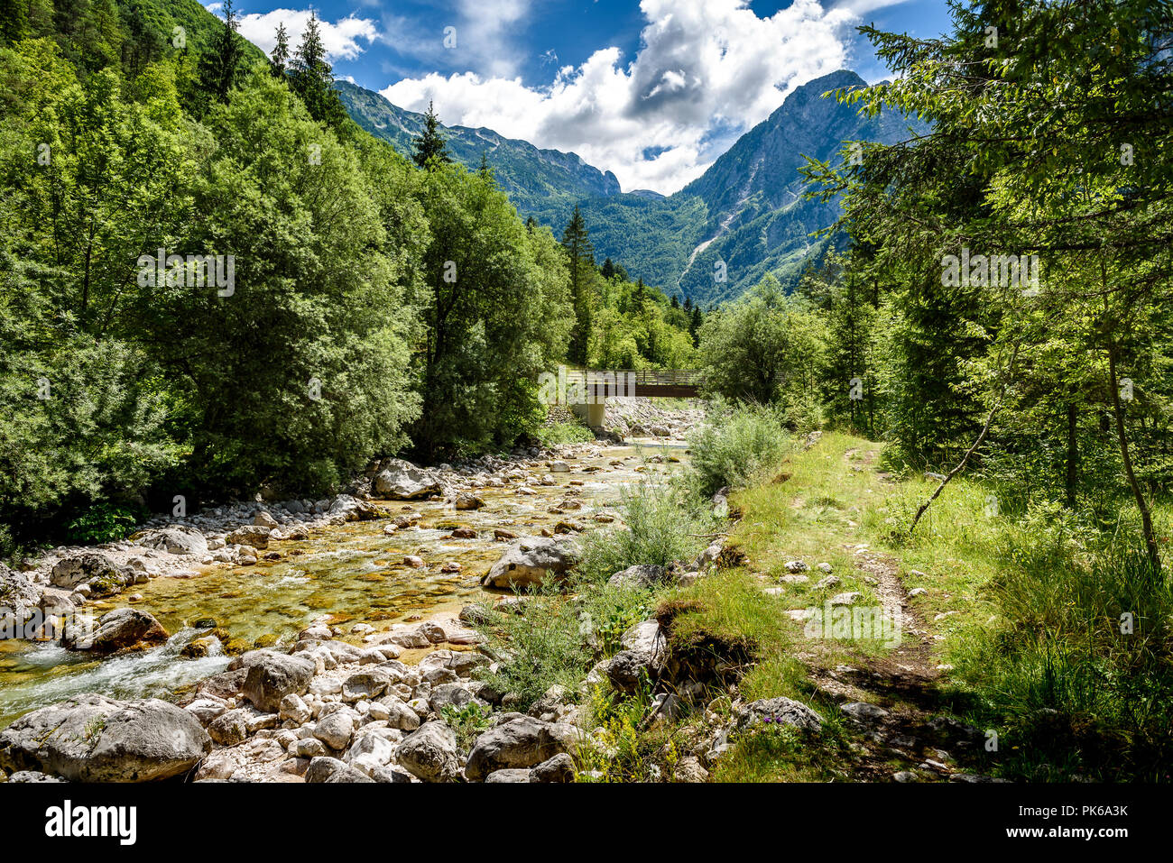 Idyllic mountain river in Lepena valley, Soca - Bovec Slovenia. Bridge over of river Lepenca when heading towards Sunik water grove. Beautiful landsca Stock Photo