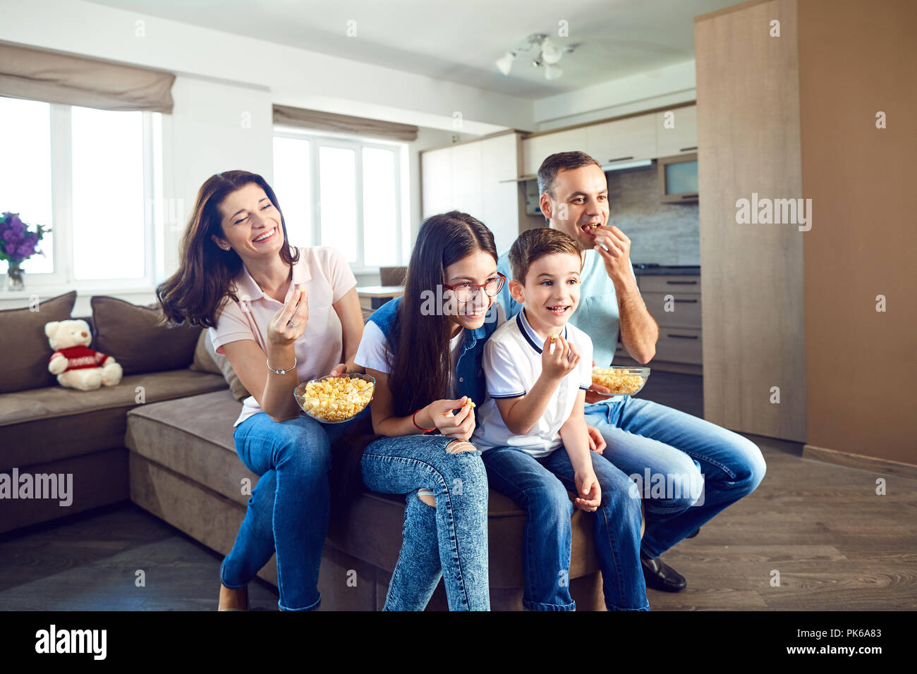 Happy family having fun watching TV. Stock Photo