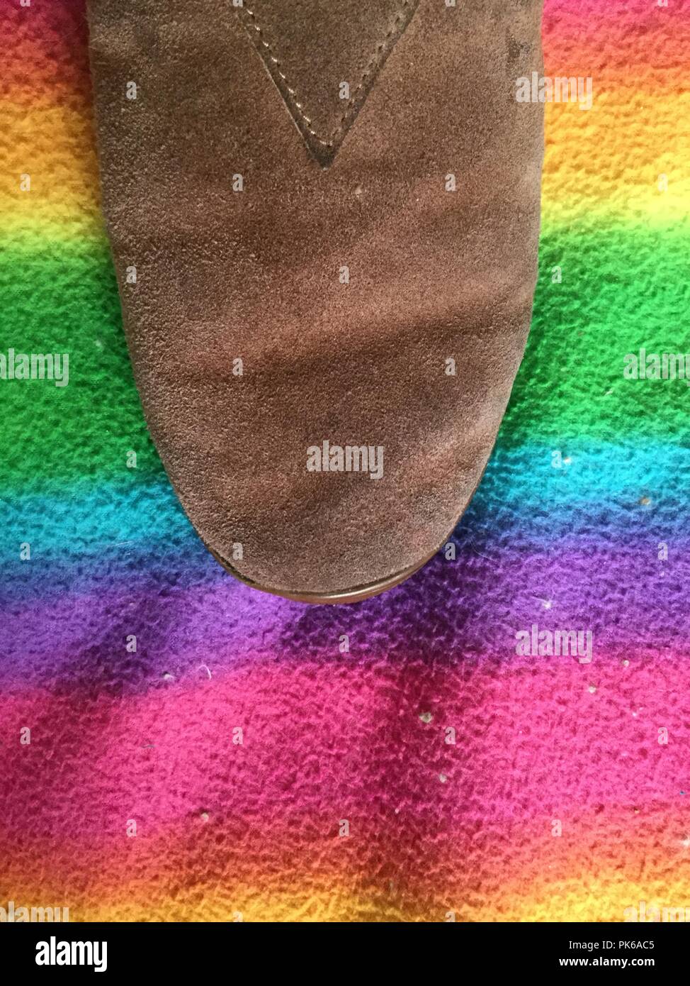 Brown shoe on rainbow fabric background. Stock Photo