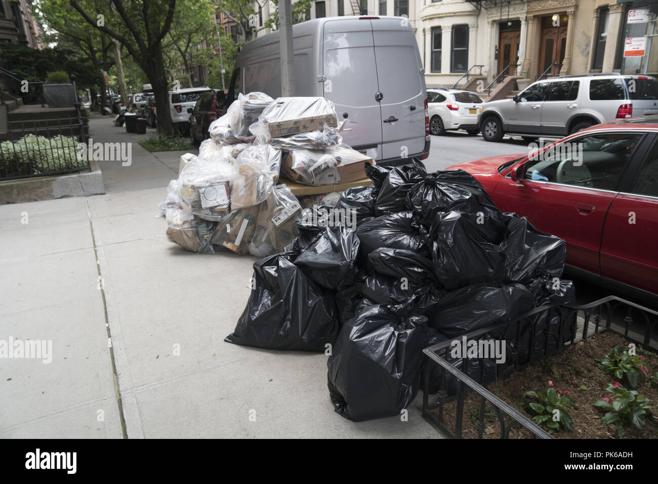 Recyclables and regular garbage on the street ready for pickup in New York City where garbage is generally put out curbside. Stock Photo