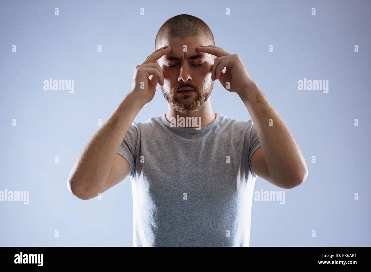 Serious young man focusing on his thoughts Stock Photo