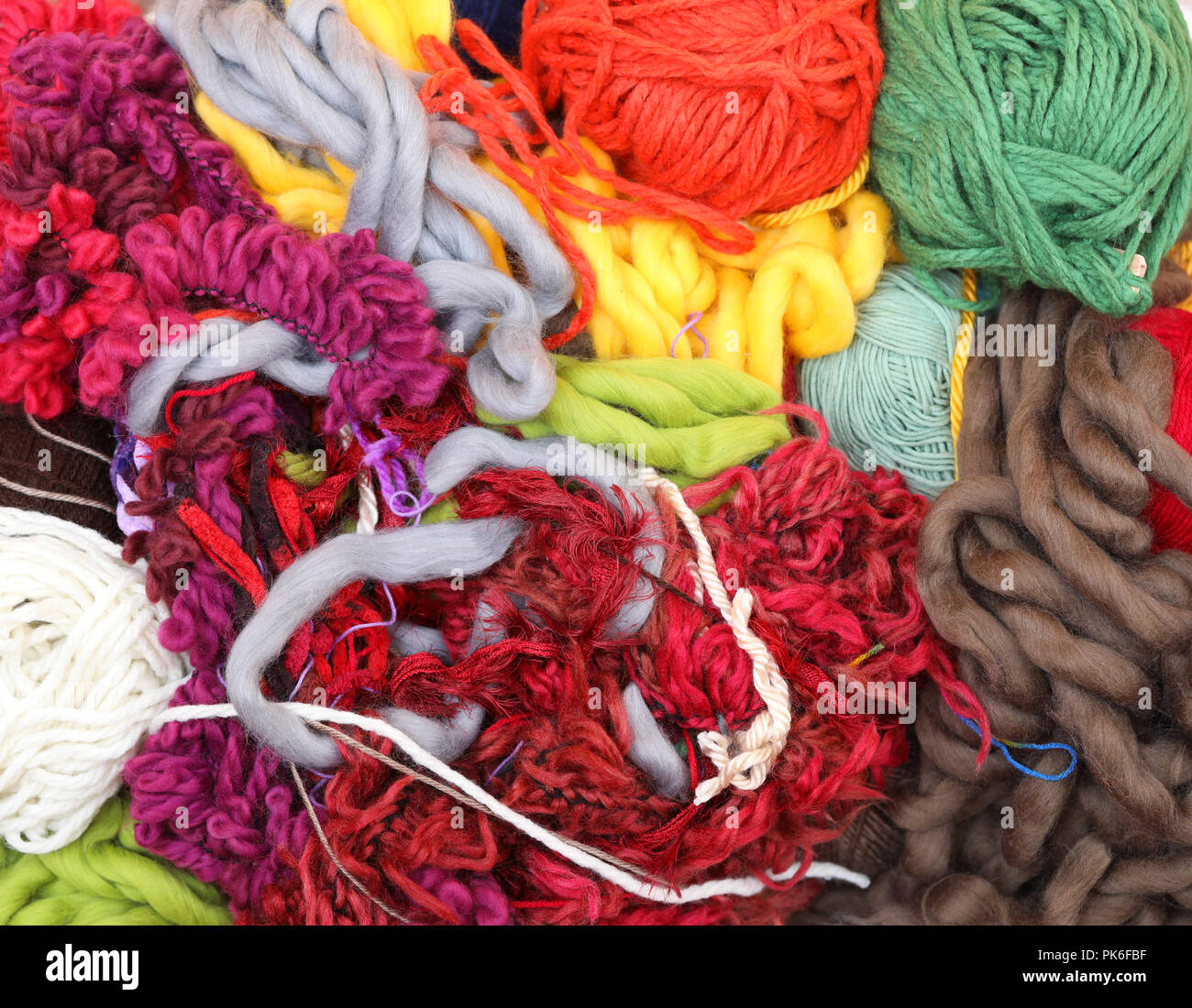 mass of woven weaving material. large bundle of fluffy thick twine and yarn wool. Lots of colour. Knitting and sewing concept. wool all tangled up. Stock Photo