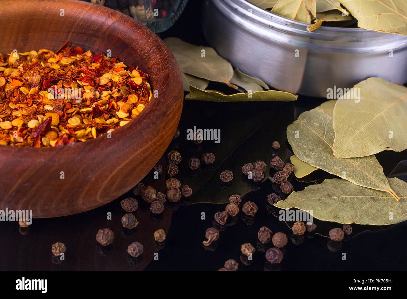 Spices and herbs, bay leaf, black peppercorn and wooden bowl of chili
