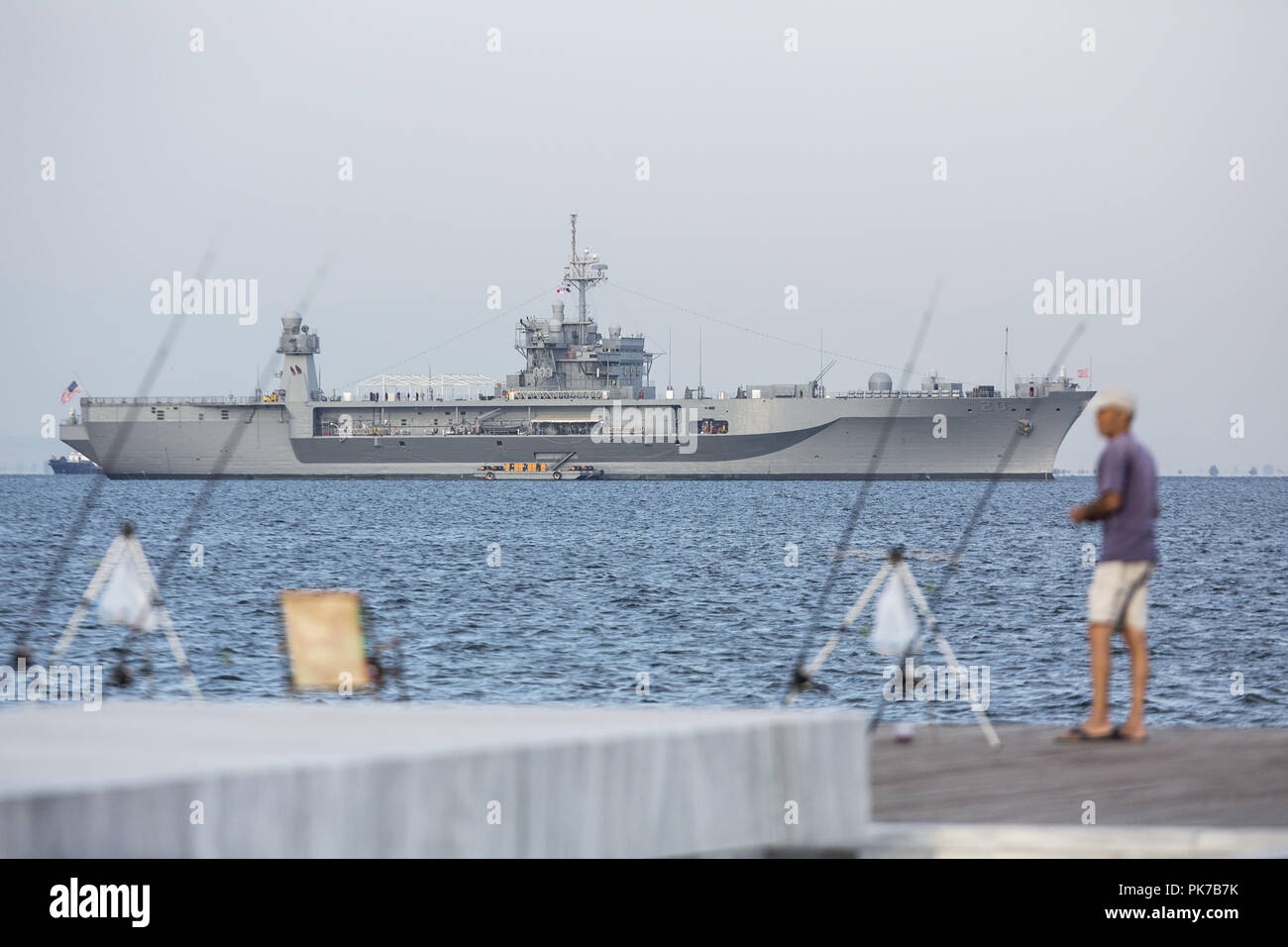 September 10, 2018 - Thessaloniki, Greece - A man fishes at the seafront of the city with the USS Mount Whitney seen at the background. USS Mount Whitney LCC-20 visits the northern Greek city of Thessaloniki during Thessaloniki International Trade Fair 2018, where USA participates as the honoured country this year. (Credit Image: © Giannis Papanikos/ZUMA Wire) Stock Photo