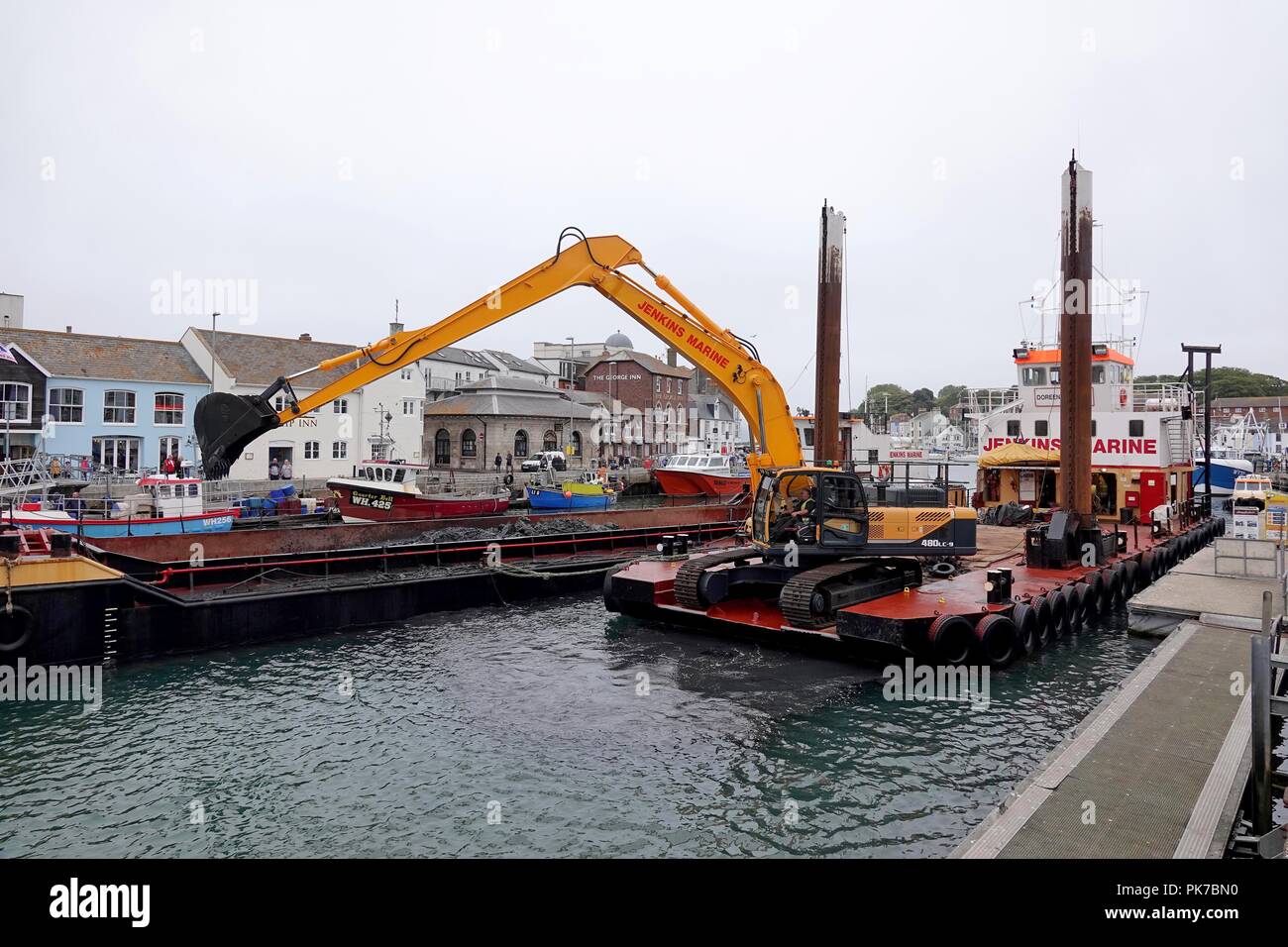 Harbour Dredging, Weymouth, Dorset, UK. 11th September, 2018. Dredging operations taking place in Weymouth Outer Harbour. The dredging platform is supported by 2 hopper barges that will transit the waste material for disposal. Credit: Finnbarr Webster/Alamy Live News Stock Photo