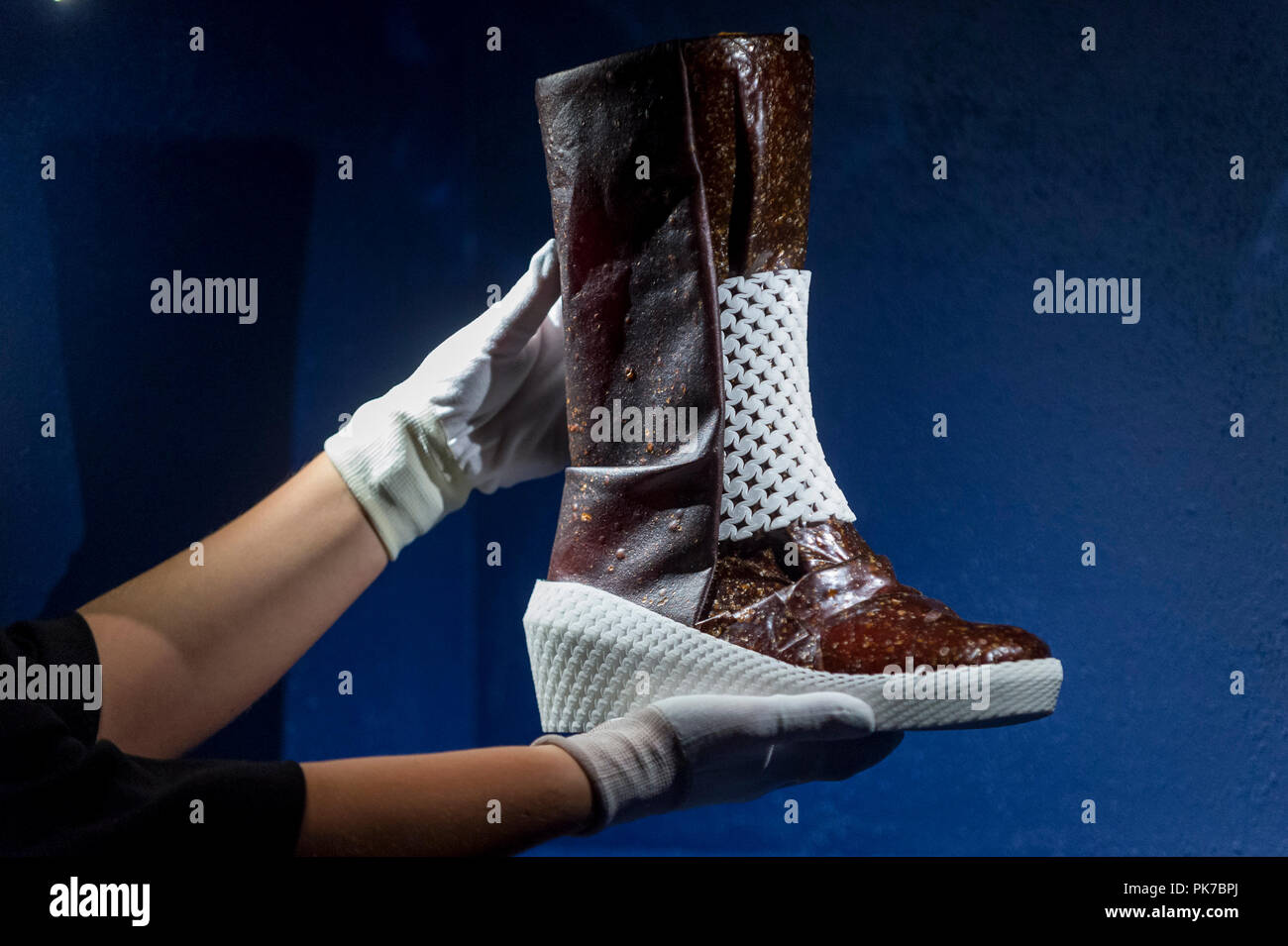 London, UK.  11 September 2018. A staff member presents 'Caskia/Growing a Mars Boot', designed by Liz Ciokajlo (OurOwnSkin) with Maurizio Montalti  at a preview of the 87 nominees for the eleventh Beazley Designs of the Year exhibition and awards at the Design Museum in Kensington.  The boot is made from mycellium fungus, fed on human sweat, and addresses the problem that Mars explorers will face in producing their own provisions and materials. The exhibition runs 12 September to 6 January 2019 and celebrates the most innovative designs of the last year.   Credit: Stephen Chung / Alamy Live Ne Stock Photo