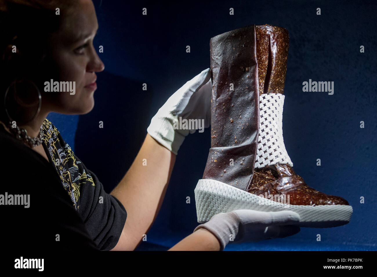 London, UK.  11 September 2018. A staff member poses with 'Caskia/Growing a Mars Boot', designed by Liz Ciokajlo (OurOwnSkin) with Maurizio Montalti  at a preview of the 87 nominees for the eleventh Beazley Designs of the Year exhibition and awards at the Design Museum in Kensington.  The boot is made from mycellium fungus, fed on human sweat, and addresses the problem that Mars explorers will face in producing their own provisions and materials. The exhibition runs 12 September to 6 January 2019 and celebrates the most innovative designs of the last year.   Credit: Stephen Chung / Alamy Live  Stock Photo