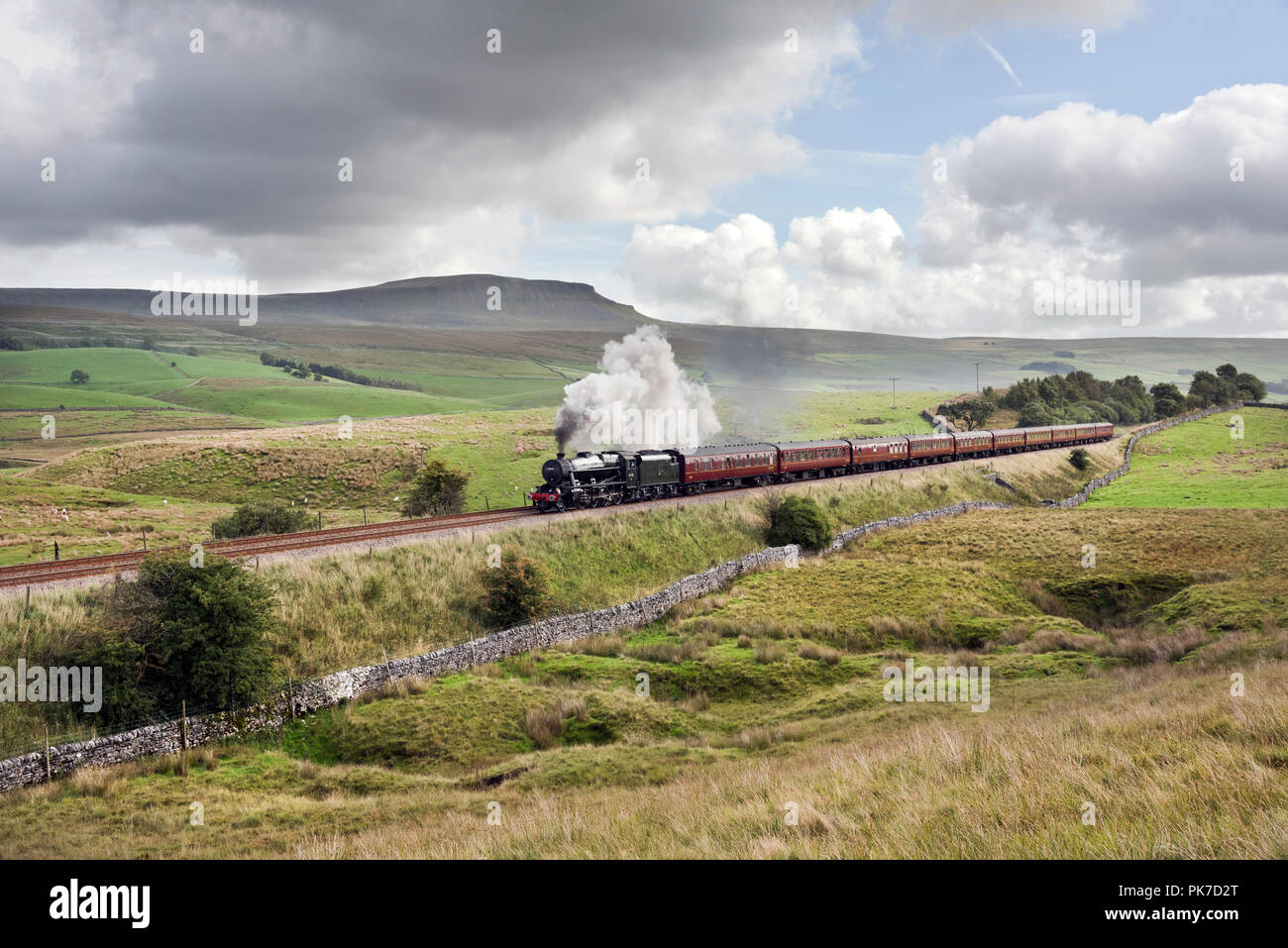 Ribblesdale, UK. 11th September 2018. 'The Cathedrals Express' passes Pen-y-ghent peak, Ribblesdale, in the Yorkshire Dales National Park. The steam special is hauled by a Stanier 8F locomotive build in 1942. The excursion originated at St Albans but is steam hauled from Hellifield (near Skipton) to Carlisle and return. Credit: John Bentley/Alamy Live News Stock Photo