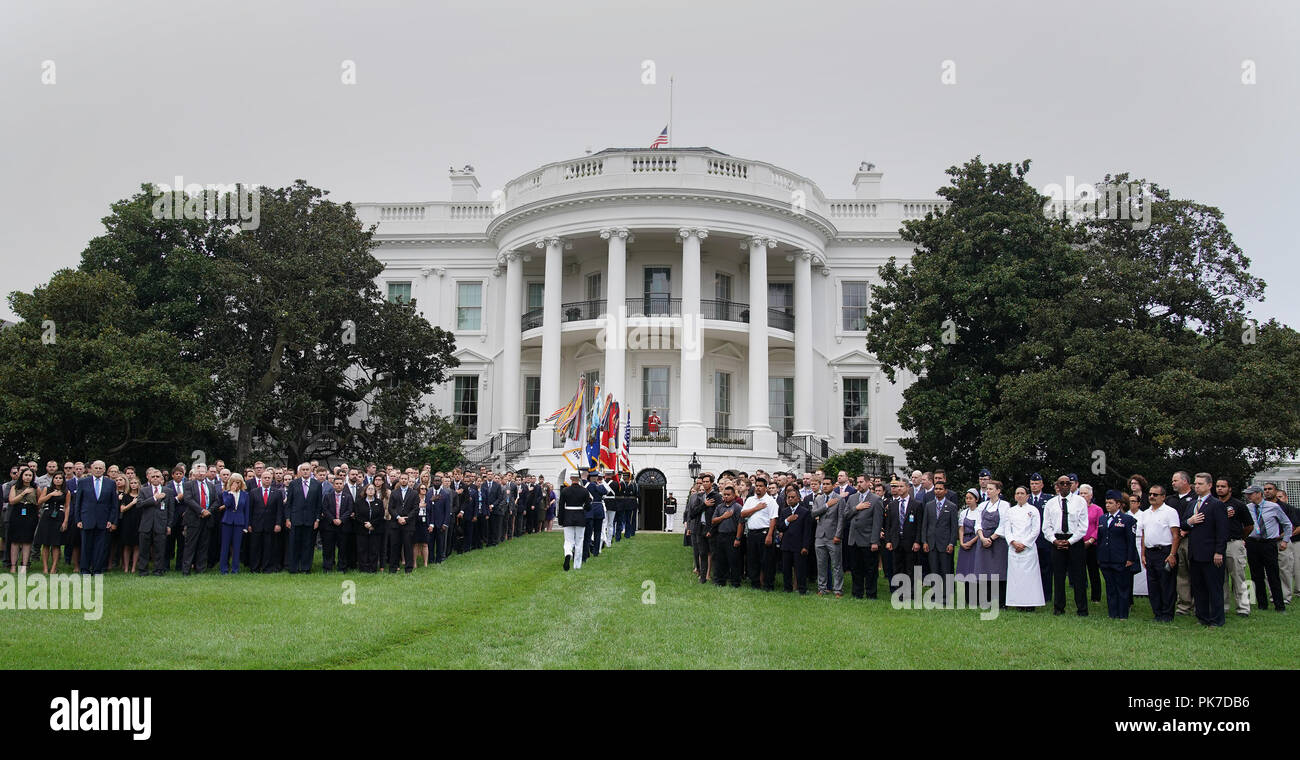 White House staff members participate in a moment of silence on the 17 anniversary of the