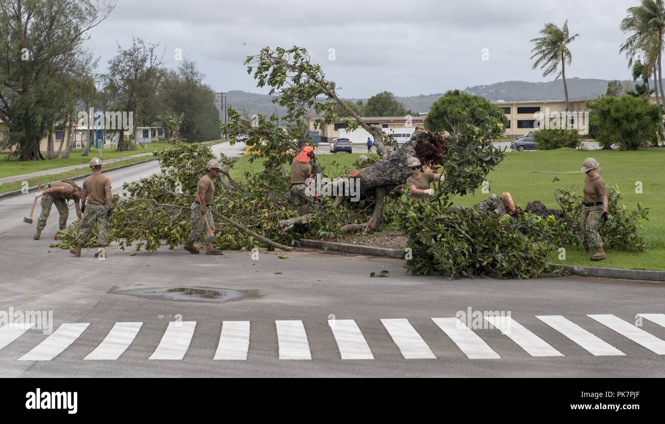Guam. 11th Sep, 2018. GUAM (Sept. 11, 2018) Sailors attached to Naval Mobile Construction Battalion (NMCB) 1, Detachent Guam, remove debris on Naval Base Guam following Typhoon Mangkhut, Sept. 11, 2018. Service members from Indo-Pacific Command are also providing Department of Defense support to the Federal Emergency Management Agency, and working with Guam and Commonwealth of the Northern Marianas civil and local officials for Typhoon Mangkhut recovery efforts. (U.S. Navy photo by Mass Communication Specialist 3rd Class Kryzentia Richards/ Credit: ZUMA Press, Inc./Alamy Live News Stock Photo
