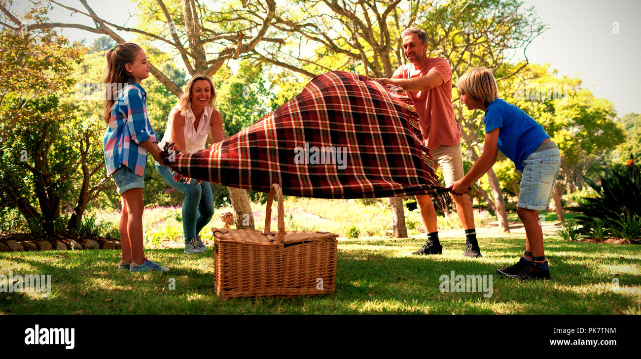 Family spreading the picnic blanket Stock Photo Alamy