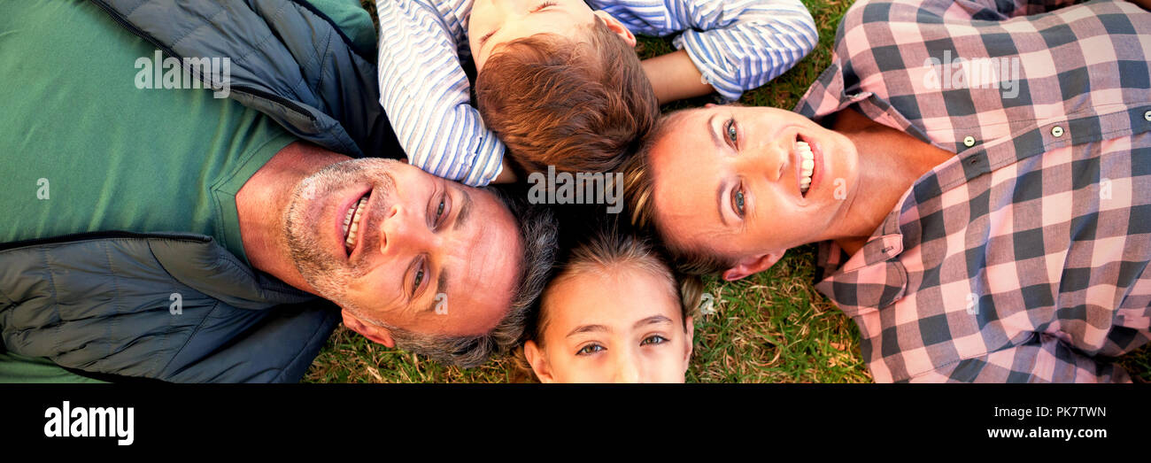 Happy family lying on the grass Stock Photo - Alamy