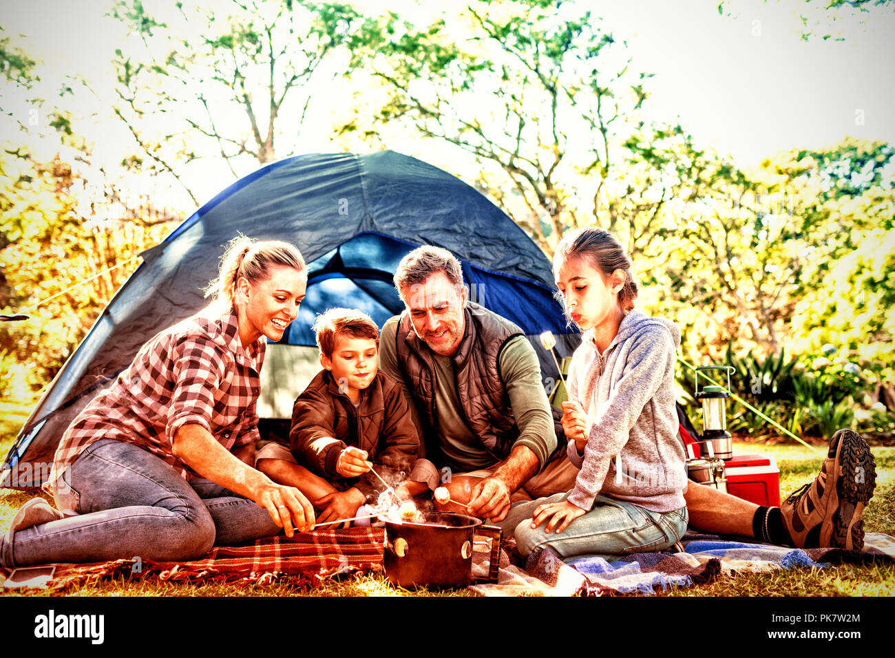 Family roasting marshmallows outside the tent Stock Photo