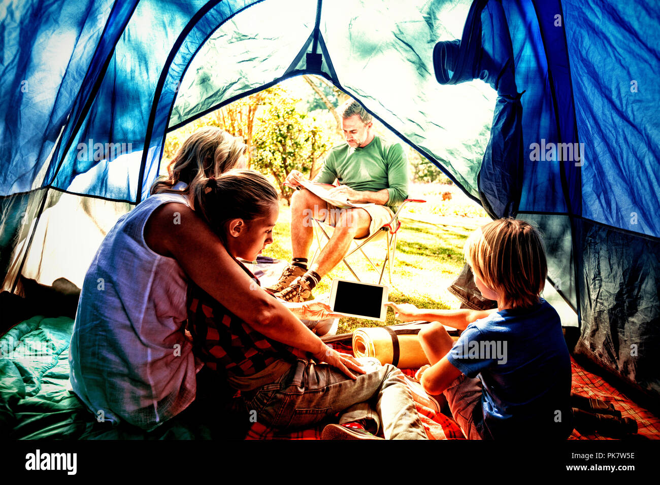 Kids and mother using tablet while father looking at the map Stock Photo