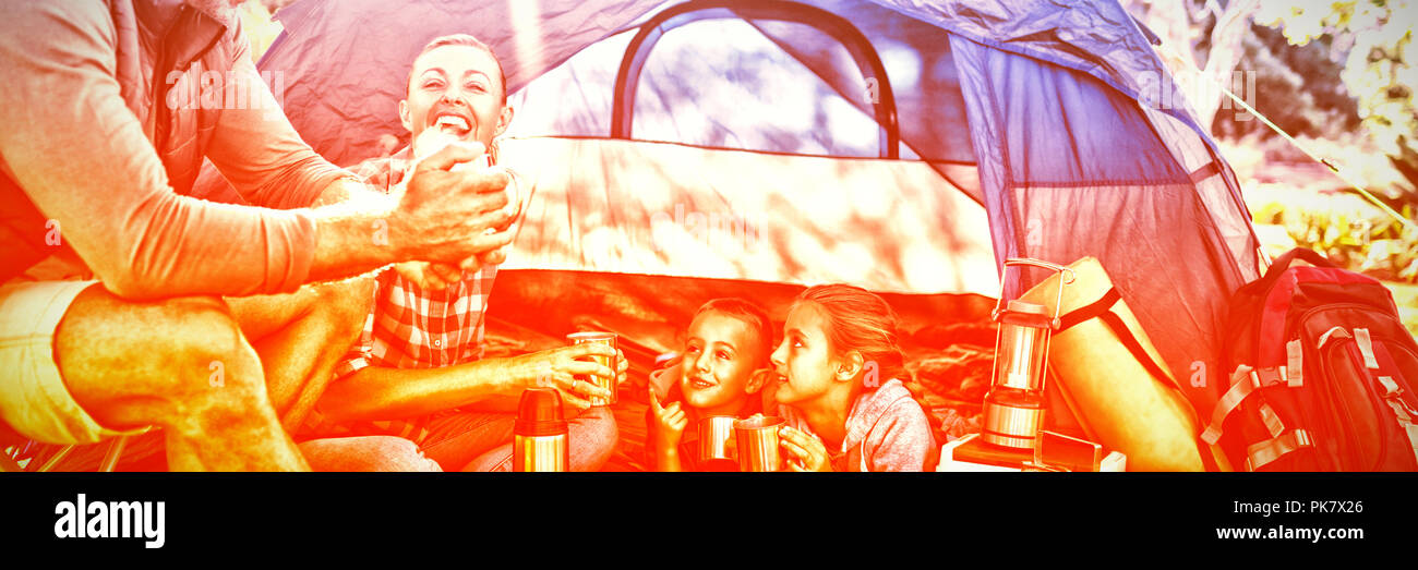 Family interacting while having snacks outside the tent Stock Photo