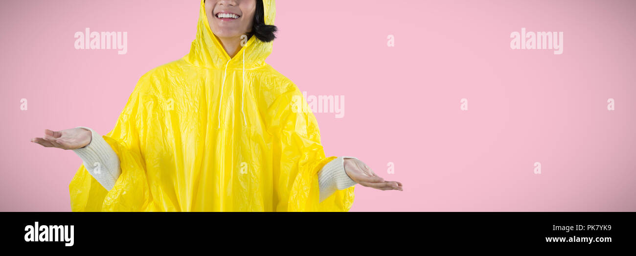 Composite image of woman in yellow raincoat gesturing to feel the rain Stock Photo