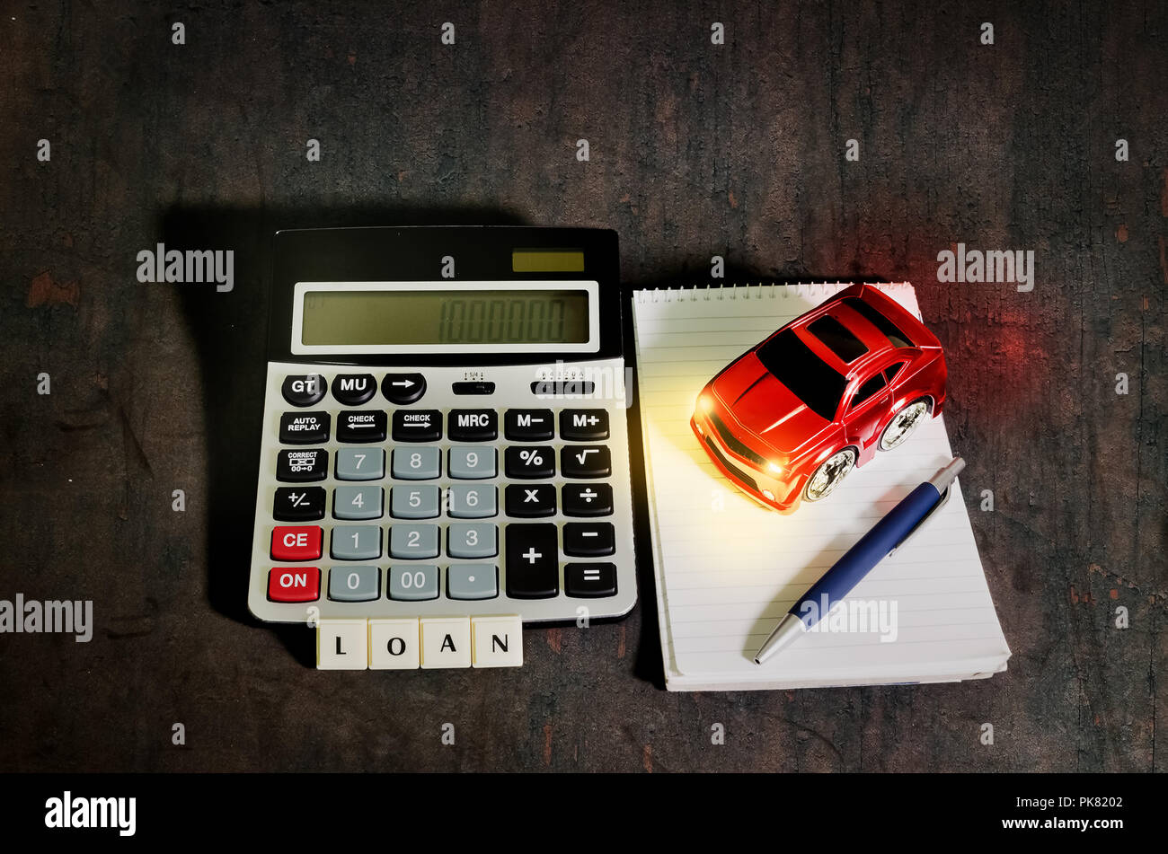 Car loan concept, a calculator beside the spiral notebook with pen and red toy car Stock Photo