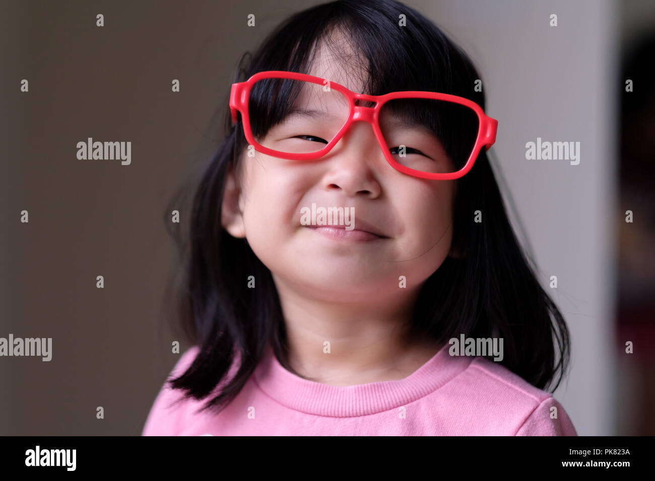 Funny little child with big red glasses Stock Photo