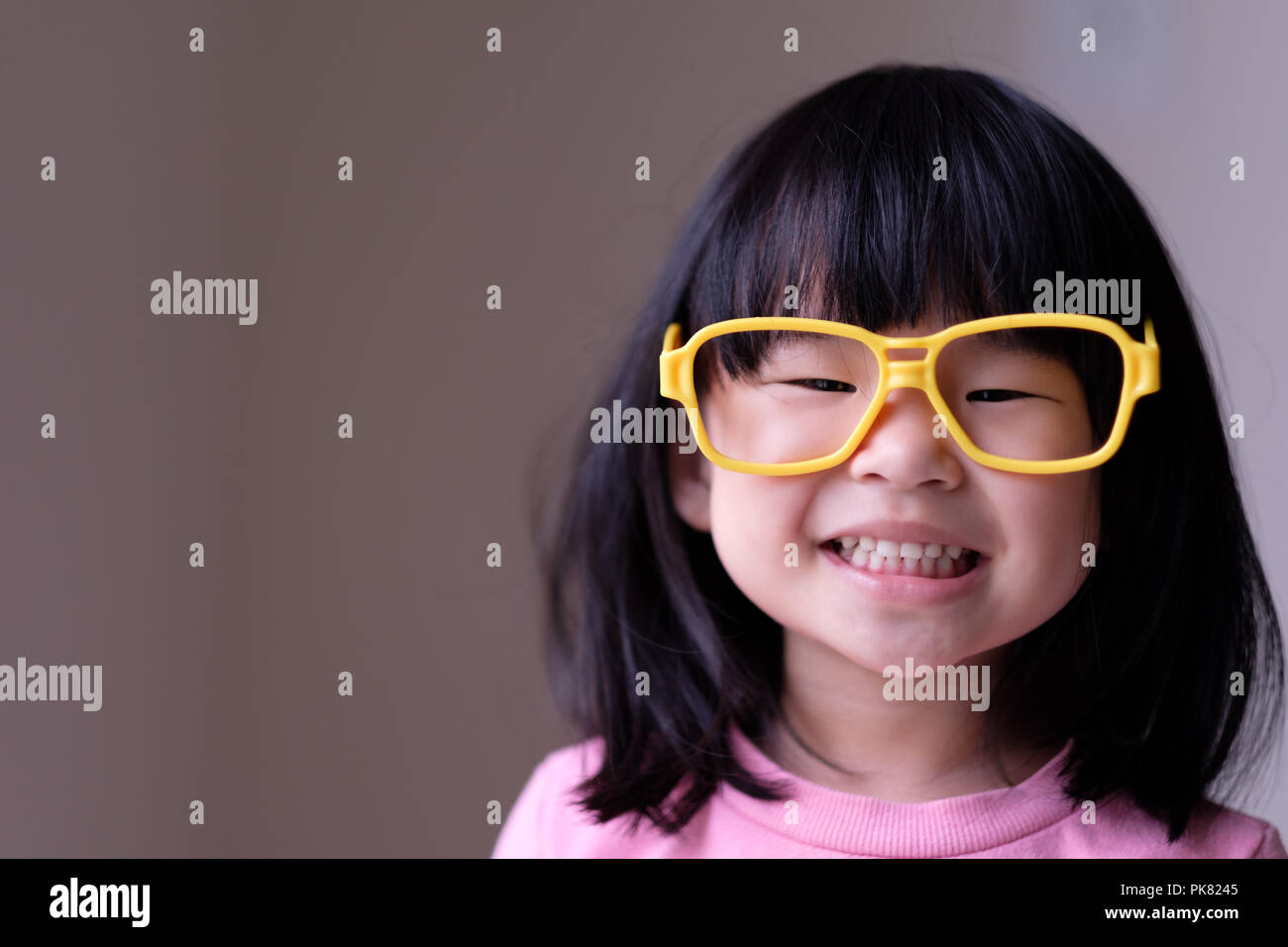Funny little child with big yellow glasses Stock Photo