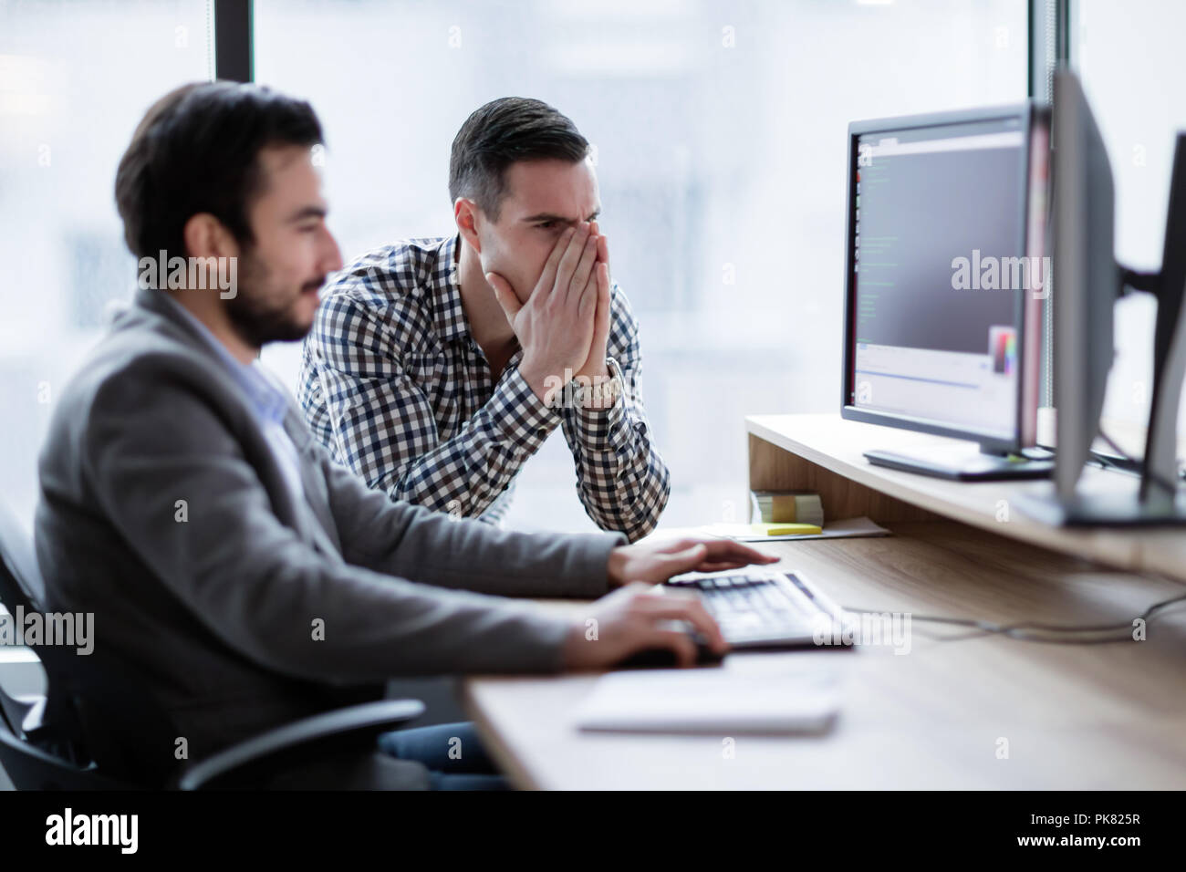 Coworkers having problem with computer in office Stock Photo