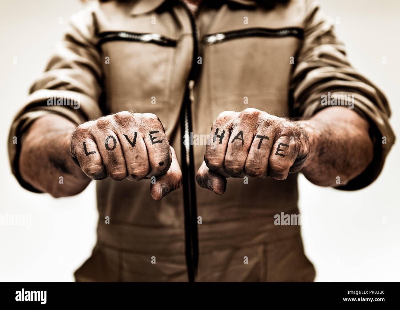 Two weathered fist with tattoo love hate pointing at camera. Stock Photo