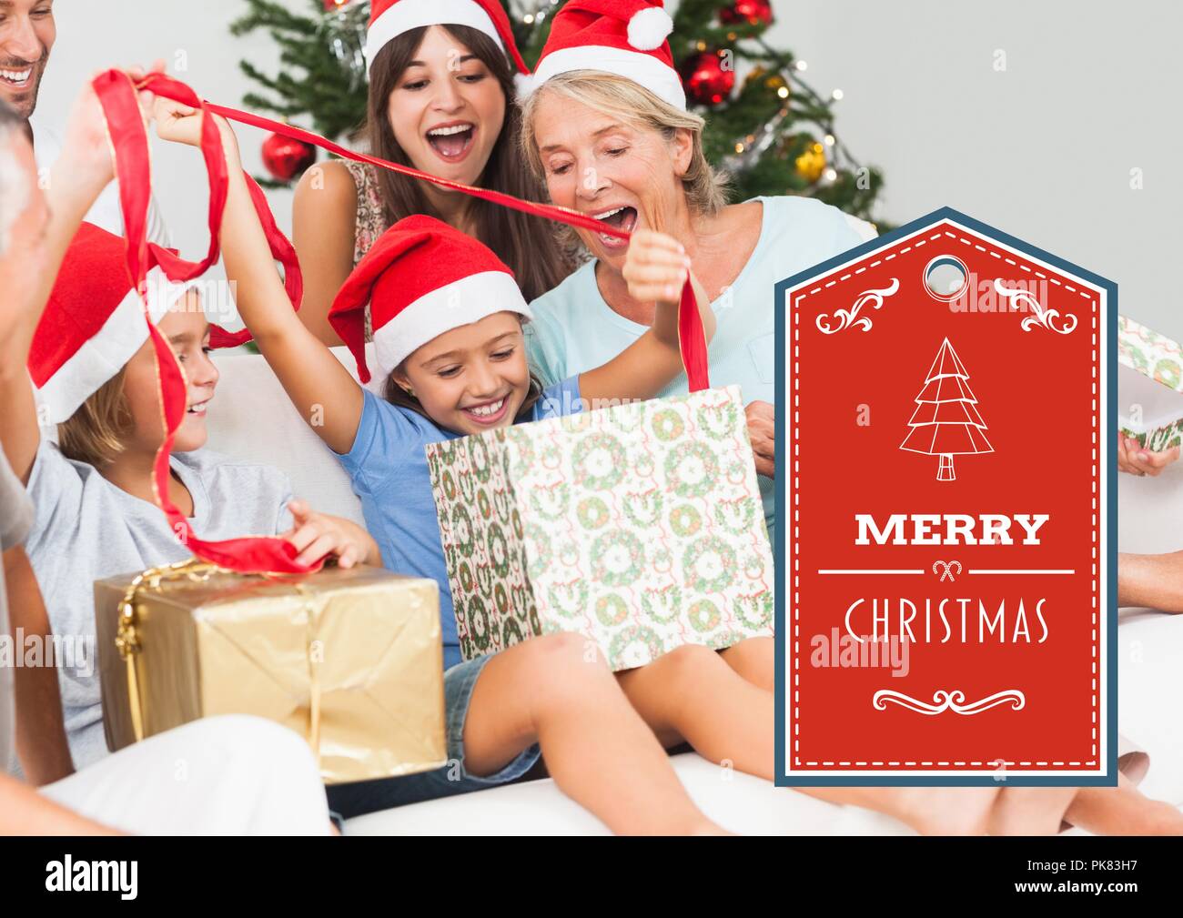 Merry Christmas text with family opening presents Stock Photo