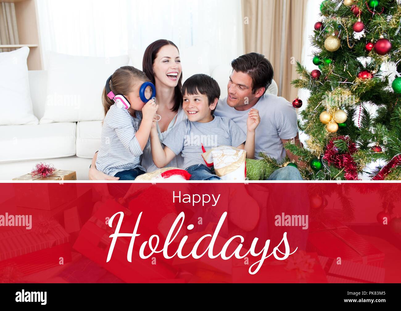 Happy Holidays text with family opening gifts at home Stock Photo